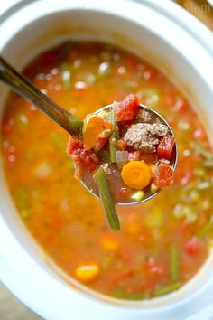 a spoon full of soup with meat and vegetables