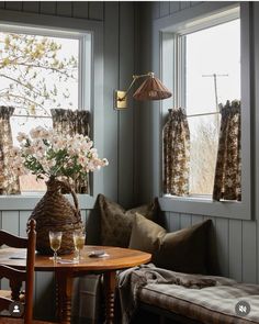 a living room filled with furniture and flowers in a vase on top of a table