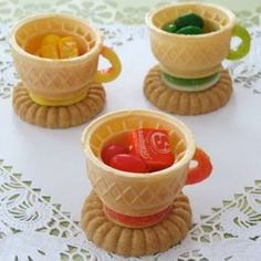 three miniature cups with candy in them on a table