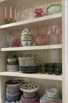 the shelves are filled with dishes and plates in pink, blue, green and white