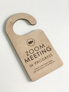 a wooden door hanger with the words zoom meeting in progress on it's front