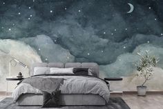 a bedroom with a bed, night sky and stars on the wall behind it is shown