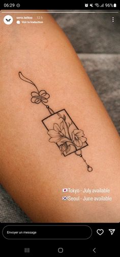 a small tattoo on the leg of a woman's arm with flowers in it