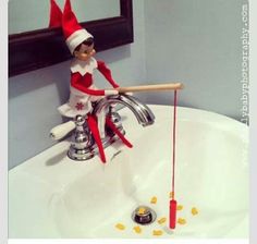 an elf sitting on top of a sink with a toothbrush