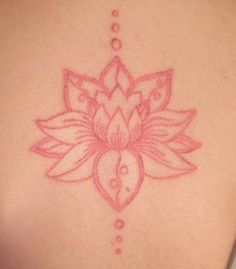 a woman's back with a lotus tattoo on it