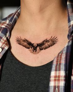 a woman's chest with an owl tattoo on it