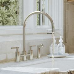 a faucet with soap and lotion in it sitting on a bathroom counter