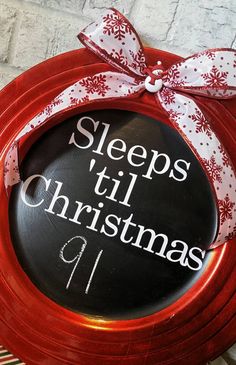 a sign that says sleeps till christmas and is attached to a red plate with a bow