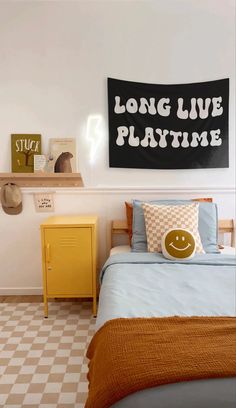 a bed room with a neatly made bed and a sign on the wall above it