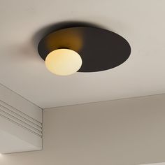 a ceiling light that is on in a room with white walls and black trim around it