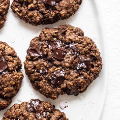 chocolate chip cookies on a white plate with sea salt sprinkled on the top