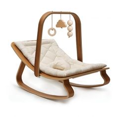 a wooden rocking chair with a white cushion on the seat and some balls hanging from it