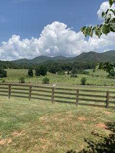 a fenced in pasture with mountains in the background