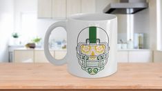 a coffee mug with a football helmet drawn on the front and side, sitting on a kitchen counter