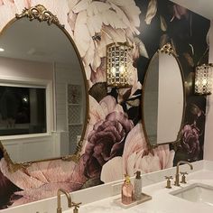 a bathroom with floral wallpaper and two sinks