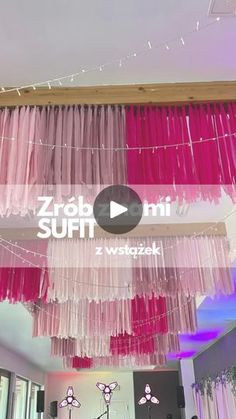 pink and purple streamers hanging from the ceiling in a room with white curtains on it