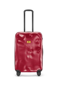 a red piece of luggage with wheels and handles on the bottom, in front of a white background