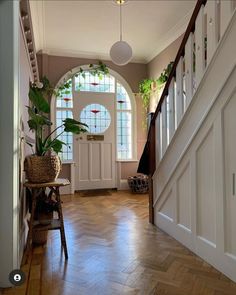 an entryway with stairs and potted plants