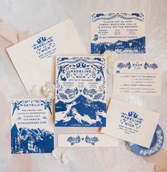 the wedding stationery is laid out on top of each other, with blue and white paper