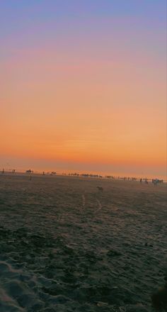 the sun is setting over the ocean with boats in the distance