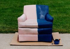 a blue and pink chair sitting on top of a cardboard box next to a green field