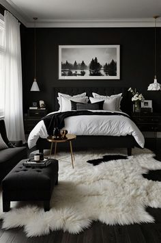 a black and white bedroom with sheepskin rugs