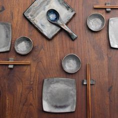 various bowls and spoons on a table with chopsticks