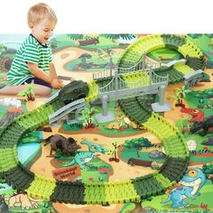 a young boy playing with a toy train set in the shape of a dinosaur bridge