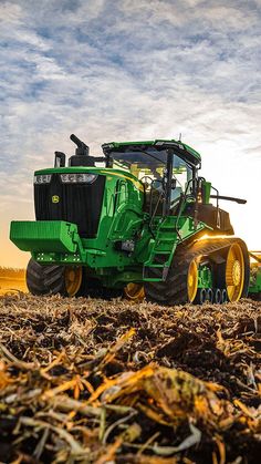 a large green tractor is in the middle of a field