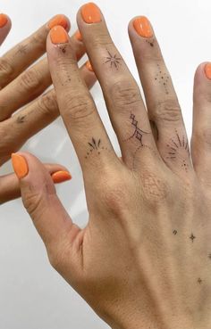 two hands with different designs on them and one has an orange manicured nail polish