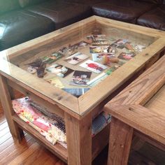 a wooden table topped with lots of pictures and papers on top of a hard wood floor