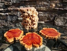 three pieces of wood sitting on top of a glass table next to a stack of stacked logs