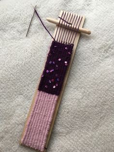 a wooden loom with purple and pink material