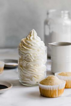 cupcakes with white frosting sitting on a table