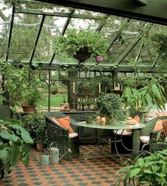 an outdoor dining area with potted plants on the table and green chairs around it