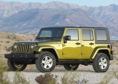 a yellow jeep is parked in the desert