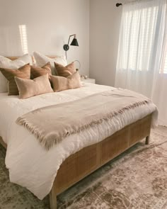 a bed with white sheets and brown pillows