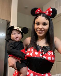 a woman in minnie mouse costume holding a baby