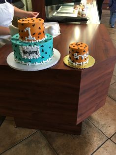 two cakes sitting on top of a wooden table