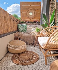 an outdoor living area with wicker furniture and rugs on the floor next to a wooden wall