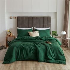 a bed with green sheets and pillows in a room