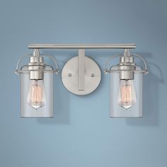 two light bathroom fixture with clear glass shades on the sides and one light bulb attached to the