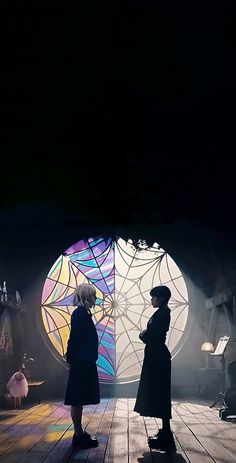 two people standing on a stage in front of a stained glass window with lights coming from it