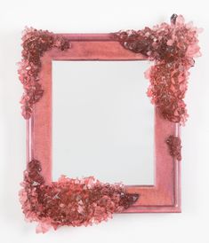 a pink frame with flowers and leaves around it