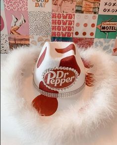 a white hat with red polka dots and a dr pepper logo on it sitting on top of a pile of posters