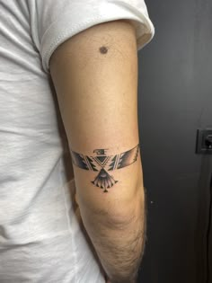 a man's arm with an eagle tattoo on the left side of his arm