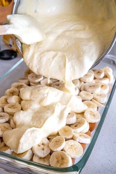 bananas and cream being poured into a glass dish