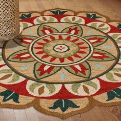 a round rug with a flower design on the floor next to a vase and wicker basket