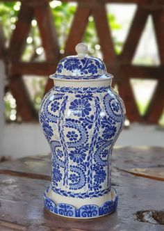 a blue and white vase sitting on top of a wooden table