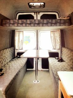 the inside of an rv with two couches and a table